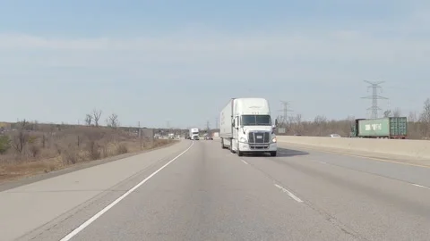 POV reverse shot driving on highway with truck and car traffic on nice day 動画素材 151901135