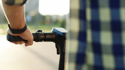 POV rides an environmentally friendly e-scooter on a city shore. Young hipster Stock Footage 194603420