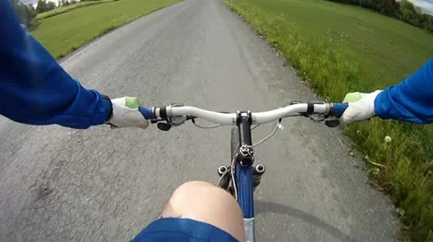 Pov riding mountain bike on gravel road Stock Footage
