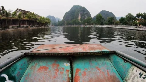 POV from rowing boat floating across river approaching small village, Ninh Binh Stock Footage 147356441