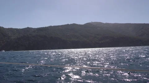 POV sailing into island cove withe afternoon sun and island ridge Video stock 67999162