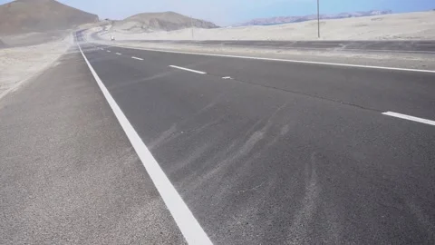POV seeing a close-up of the sand being displaced all over the road by the stron Stock Footage 196728763