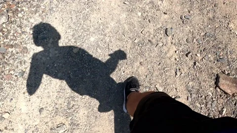 Pov seeing the shadow of me running on dirt and stones in the highlands at sunny Stock Footage 199550298