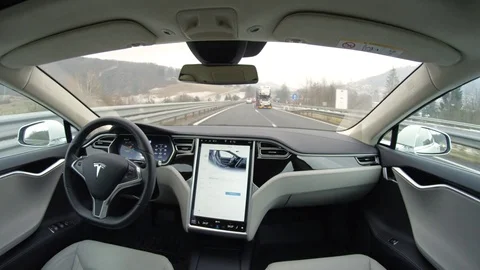 POV: Self-driving fully autonomous Tesla driverless car driving on highway Stock Footage 73123775