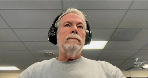 POV to a senior man  using an elliptical machine at his gym Stock Footage 283301781