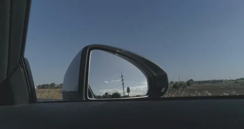 Pov shoot of front mirror of white car driving on asphalt at countryside view Stock Footage 100032480
