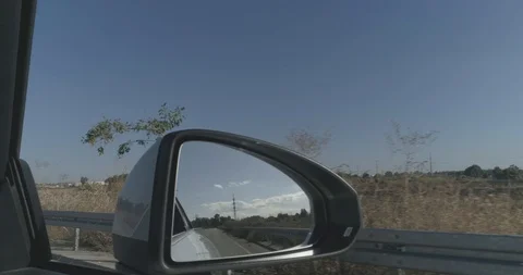 Pov shoot of front mirror of white car driving on asphalt at countryside view Video stock 100032657