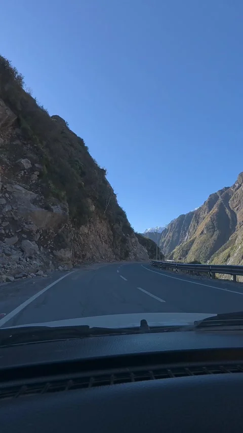 POV Shot from a Car Driving through High Mountain Pass with Clear Blue Sky Stock Footage 328831754