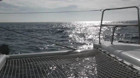 POV shot looking forward on catamaran as it cuts through waves under full sai Stock Footage 67864155