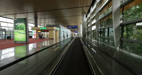 POV shot on moving walkway inside Kunming airport terminal Видео 329627008