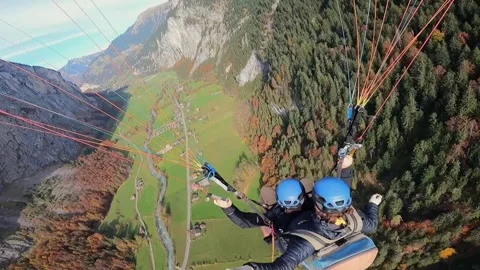 Pov shot of paragliding flight over idyllic swiss mountains in autumn Видео 295036089