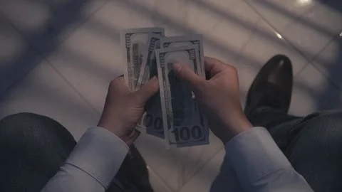 POV shot of person counts a stack of dollar bills while seated Stock Footage 279106370