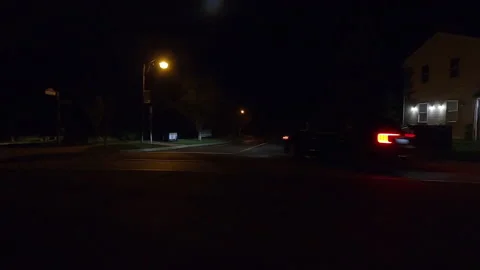 POV side view driving in car traffic on a very dark night on city streets Stock Footage 162019883