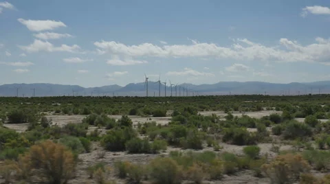 POV-Side window-Passing rows of wind turbines in desert Stock Footage 64670232