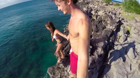 POV Slow Motion Cliff Jumping. Athletic Young Couple Holding Hands Jumping Fr Stock Footage 57223687