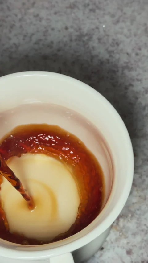 POV slow motion shot of steaming hot coffee being poured into a white mug Stock Footage 312966886
