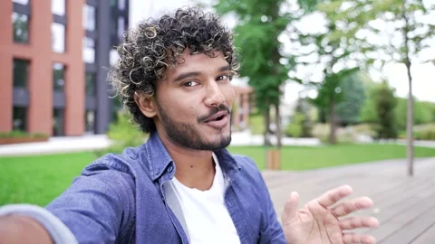 POV Smiling student talking on a video call using a mobile phone while standing  Stock Footage 302471998