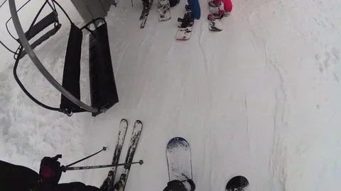 POV of snowboarders riding on a lift at a ski resort. Stock Footage