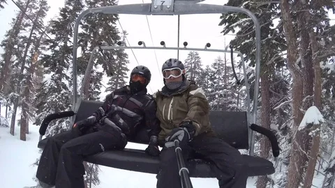 POV of snowboarders riding on a lift at a ski resort. Stock Footage