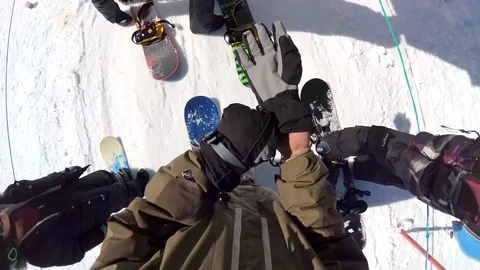 POV of snowboarders riding on a lift at a ski resort. Stock Footage