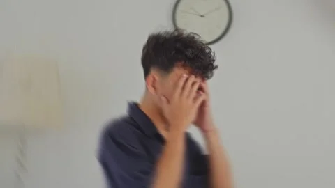 POV spinning effect shows young Asian man losing balance and holding face from 库存影片 335484054