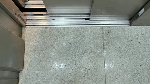 POV. Steel elevator door opens. Feet with black socks and shoes walking. Stock Footage 125196474