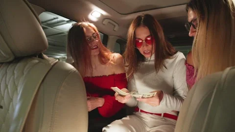 POV Three Joyful girlfriends Split the Fare and Pay the Taxi Driver with Dollar Stock Footage 288510253