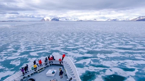 A POV time lapse shot of a ship bow, icebergs and tourists passing through Stockbeeldmateriaal 107568306