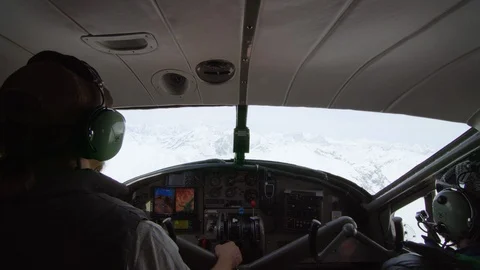 POV of two pilots in the cabin of small airplane over Alaskan mountains Stock Footage 129129679