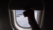 Pov: Unknown Person Pulls Up Airplane Window Shade And Reveals Bright Blue Sky. Stock Footage