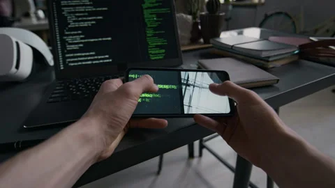 POV of Unknown Young Man Reading HTML Code Holding Smartphone at Workplace Stock Footage 299687744