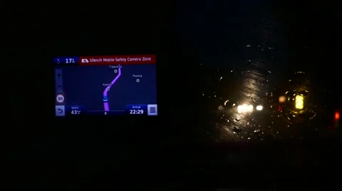 POV using a car GPS to navigate while driving at night on a rainy road Stock Footage