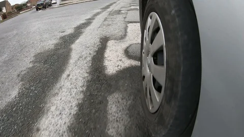 POV Van tyre driving over a damaged road which is covered in Potholes Stock Footage 123318642