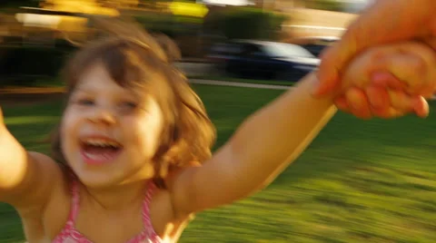 POV video father spinning happy girl daughter child kid around in park at sunset Stock Footage