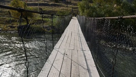 POV video of walking through old shaky suspension bridge Stock Footage 82686344