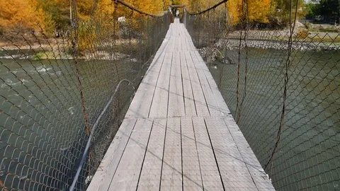 POV video of walking through old shaky suspension bridge Видео 82687217