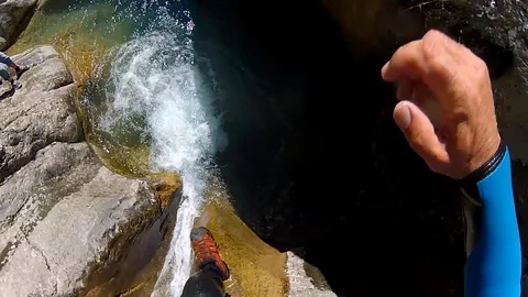 POV view of action camera jumping in water from the rock. Canyoning activity. Stock Footage 128177492