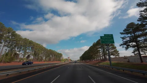 POV view from the car driving on the empty highway under a bright blue sky with Stock Footage 315723031