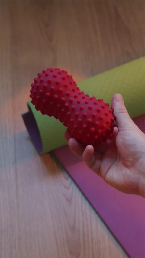 POV view demonstrating red spiky massage ball over mat 스톡 동영상 346546048