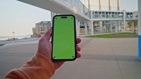 POV View Of Hand Holding Smartphone With Green Screen On Bright Sunny Day Stock Footage 312961753