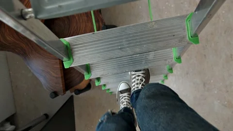 POV view of a man walking down the steps of a stepladder Stock Footage 202591888
