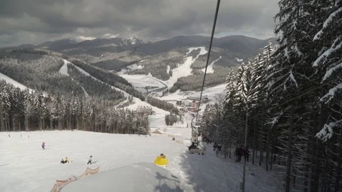 POV view from mountain elevator at winter resort with skiers 動画素材 101187101