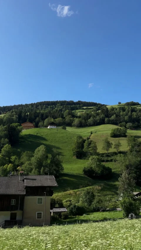 POV view from moving car window of alpine wooden house in green Dolomites Alps Stock Footage 341768755