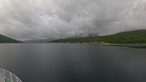POV view sailing towards coastal village under misty green mountains in Norway 库存影片 341814672