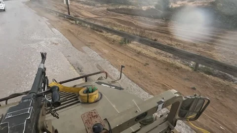 POV view of soldier eating while riding military vehicle on wet road. Video stock 332589075