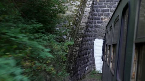 POV view from train window on railroad track entering a narrow mountian tunne Stock Footage 325560347