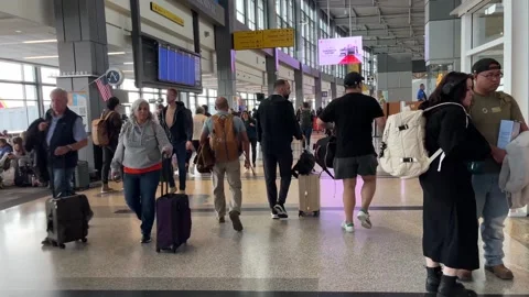 POV view walking through busy airport terminal travelers with luggage Stock Footage 256255342