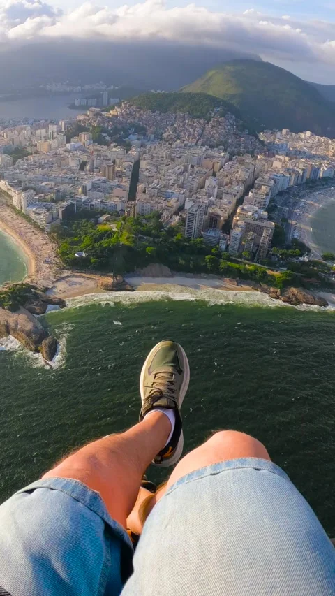 POV view of a young man paragliding over the urban coastline, Arpoador rock Stock-Footage 345736502