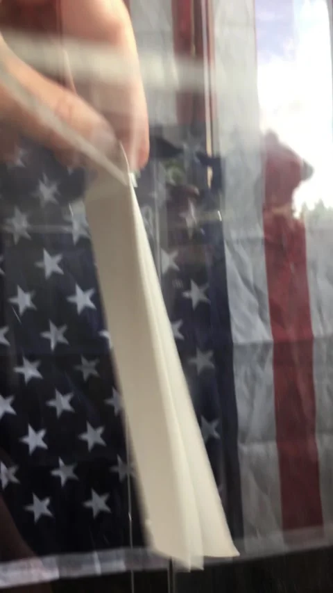 POV of voter inserting ballot sheet into slot of transparent box at US polling Stock Footage 342801424