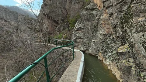 POV Walk on Canyon Edge 4K – High Cliff Path with Water Channel &amp; Stone Walls Video stock 332171753